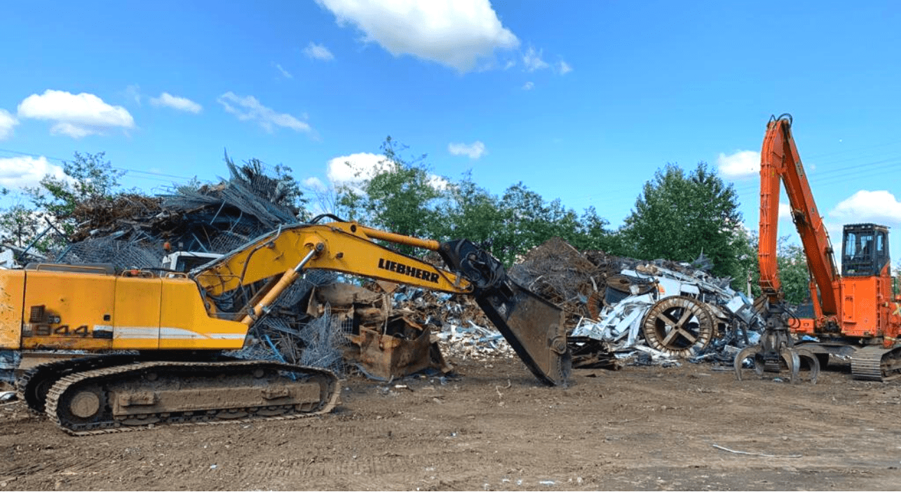 Material handlers sorting ferrous and non-ferrous scrap at the AMIX Recycling yard